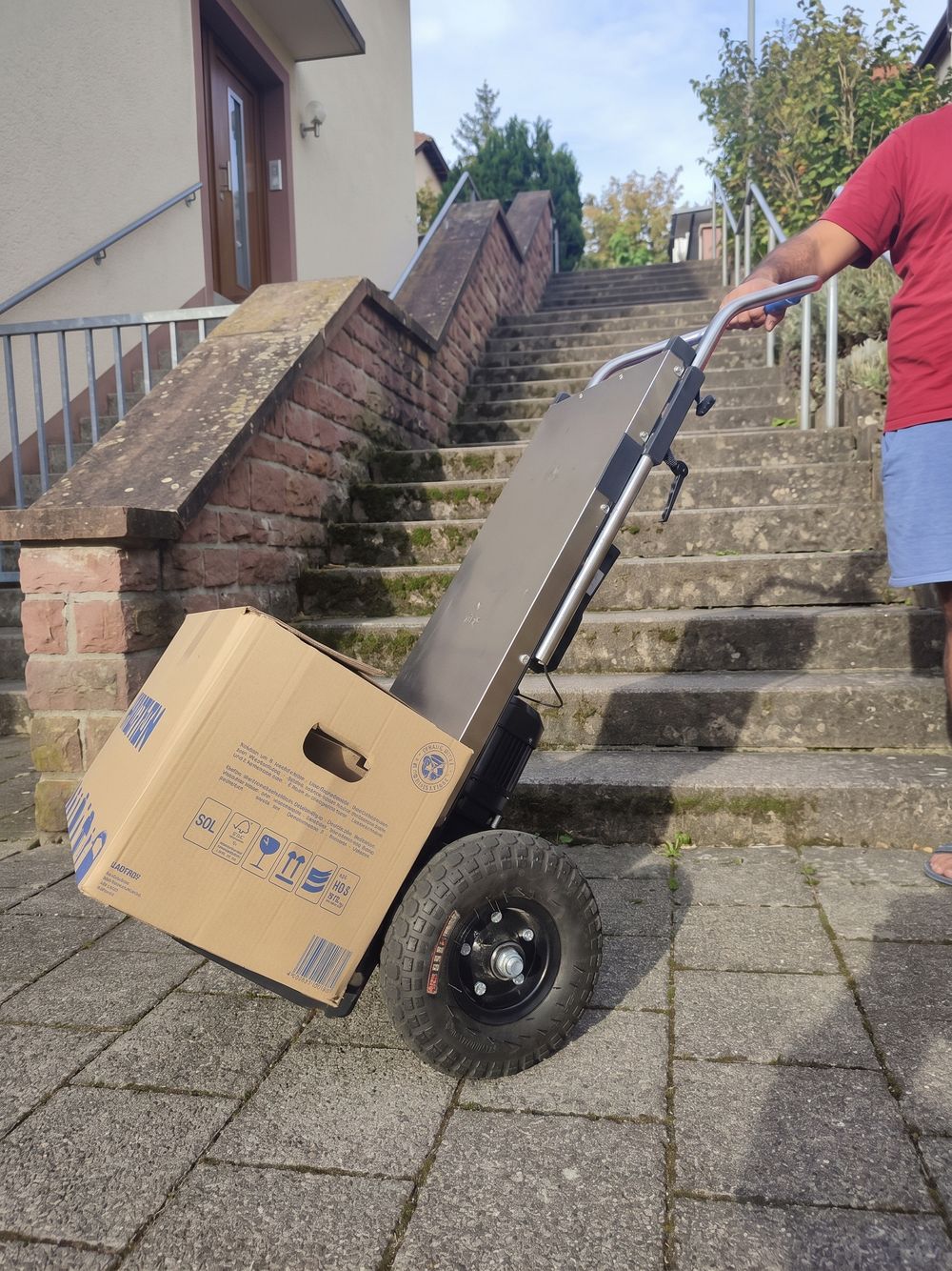 Treppensteiger wird gekippt an einer Außentreppe geführt